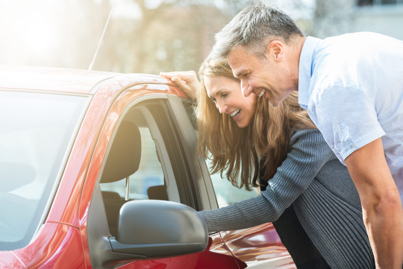 Happy couple looking at car for sale in New Bern